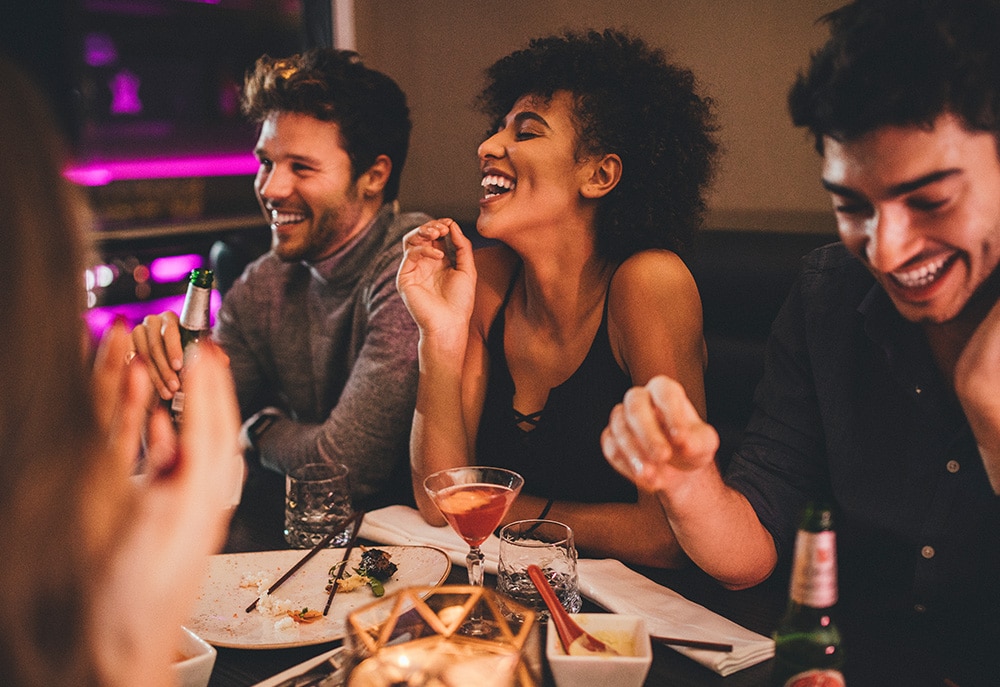 A group of friends around a dining table enjoying the nightlife